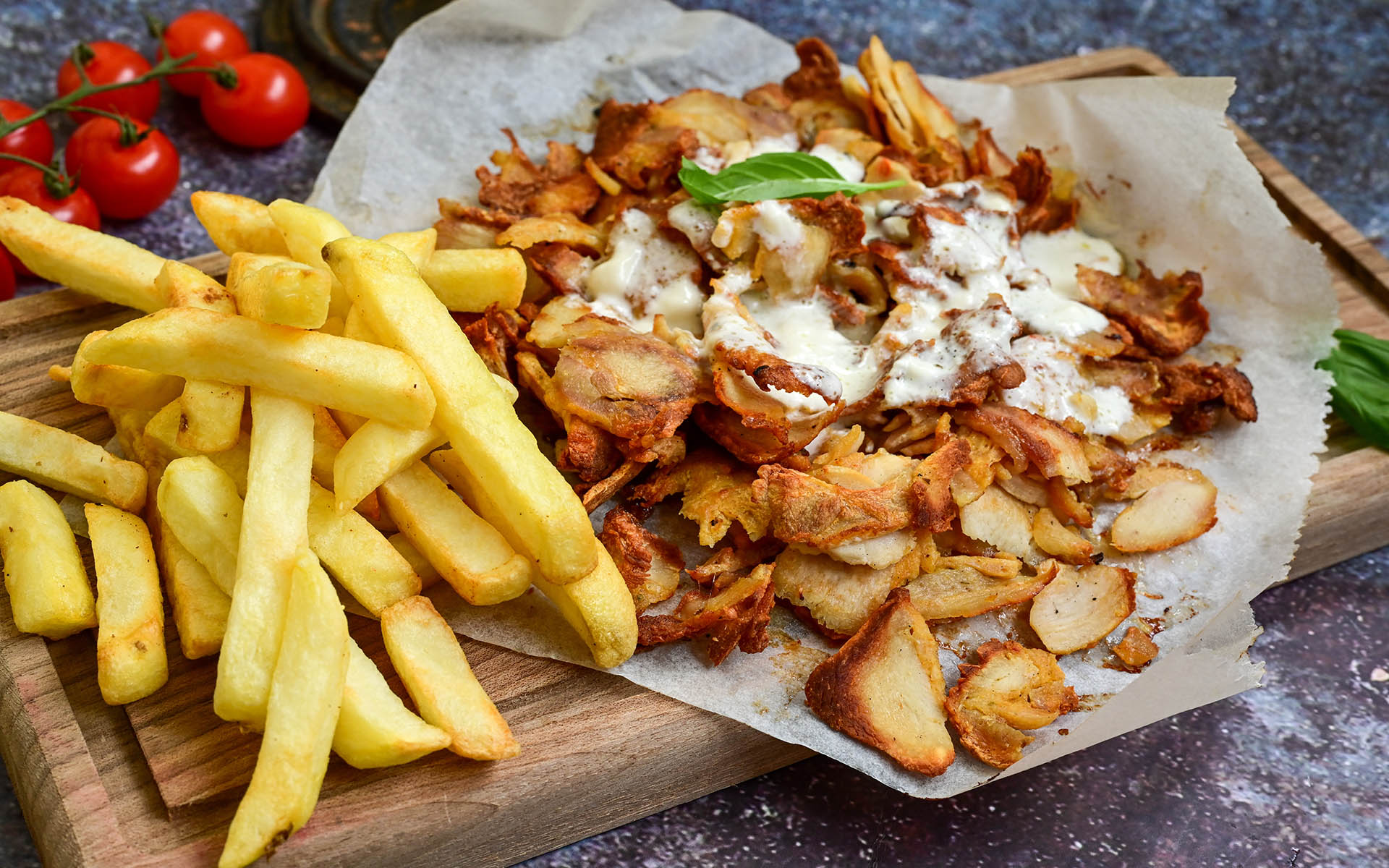 Portion of Spicy  kebab  Chicken  duner  gyros with french fries and garlic sauce  on  wooden board