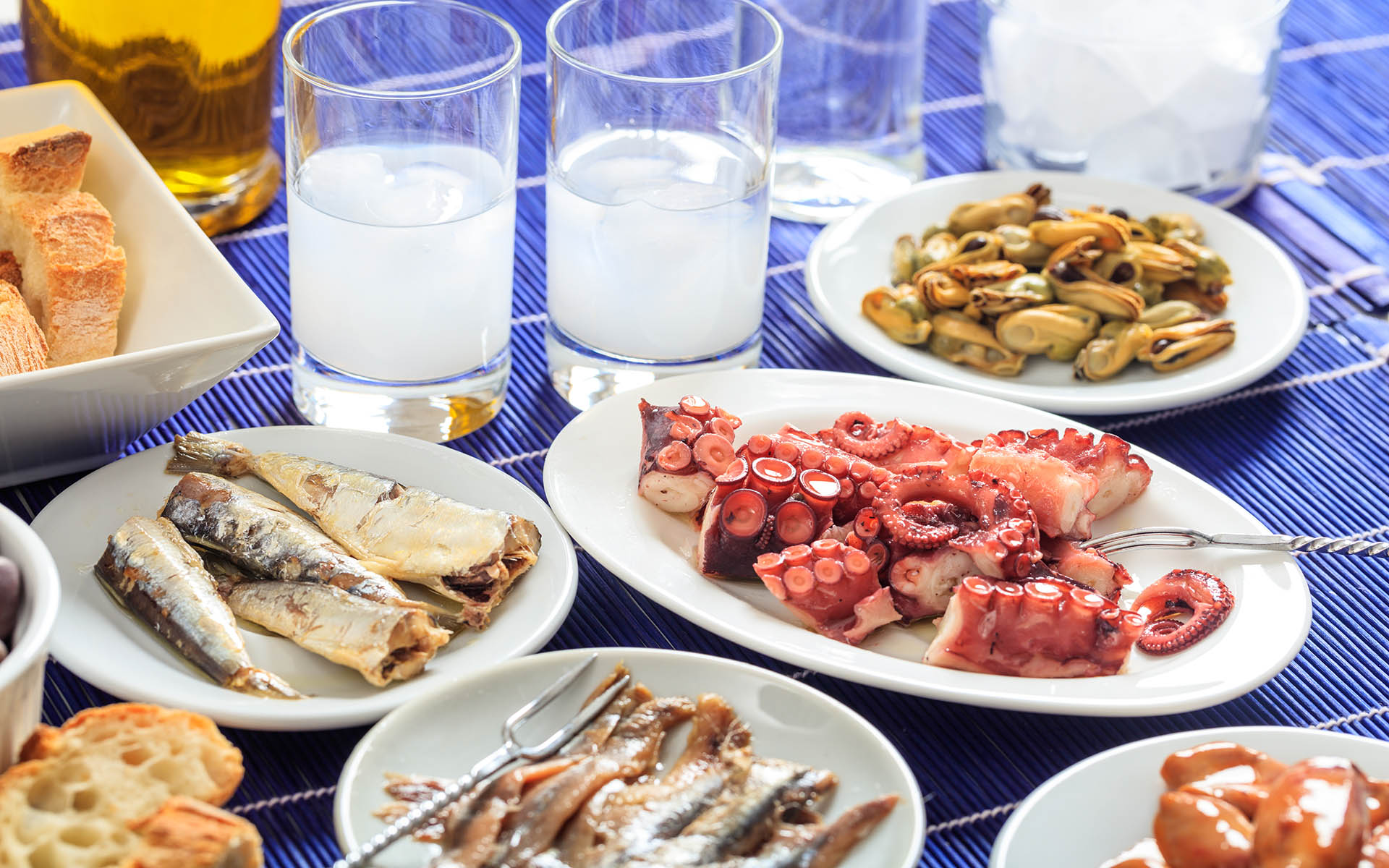 Raki and meze for two. Glasses of greek ouzo and seafood appetizers variety